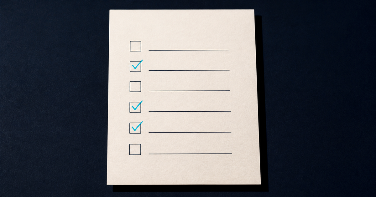 A print-magazine still life of a warm off-white sheet on navy printed with six ruled checkboxes, three ticked in cyan ink